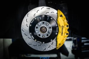 Neotech front brake disc fitted behind the yellow Brembo caliper on a Nissan GT-R R35, curved slots visible