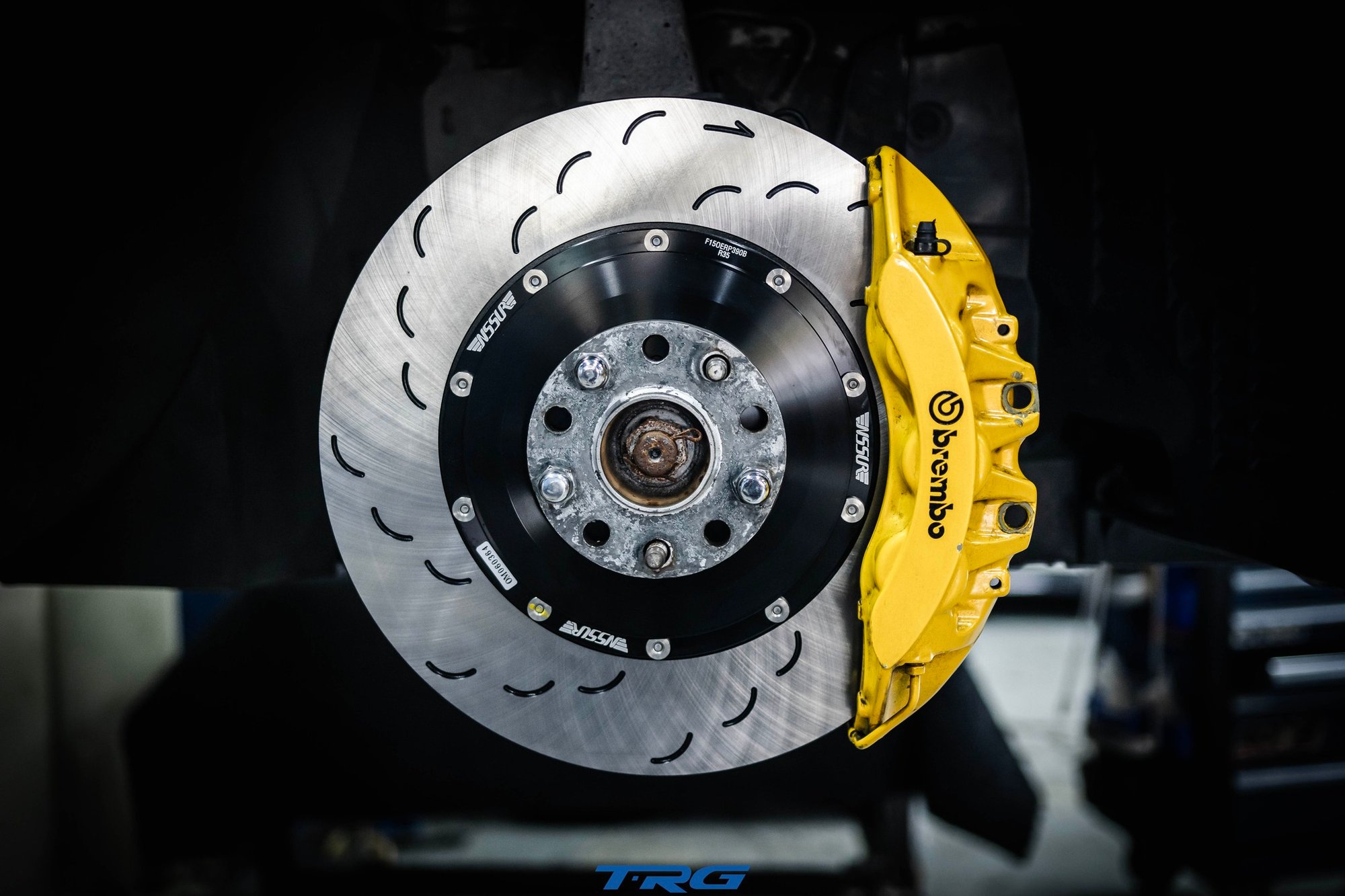 Neotech front brake disc fitted behind the yellow Brembo caliper on a Nissan GT-R R35, curved slots visible