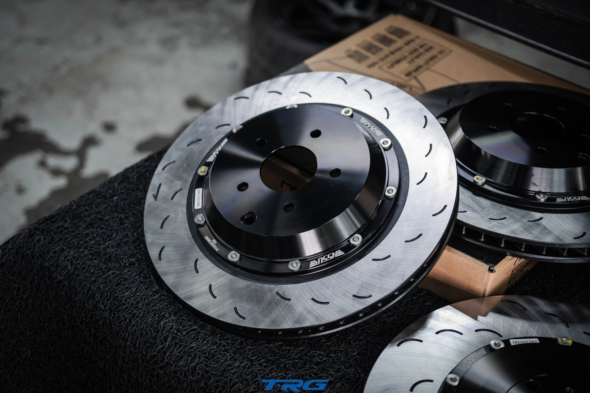 Two piece Neotech brake disc on the bench, black anodised aluminium hat, floating bobbins and curved slots