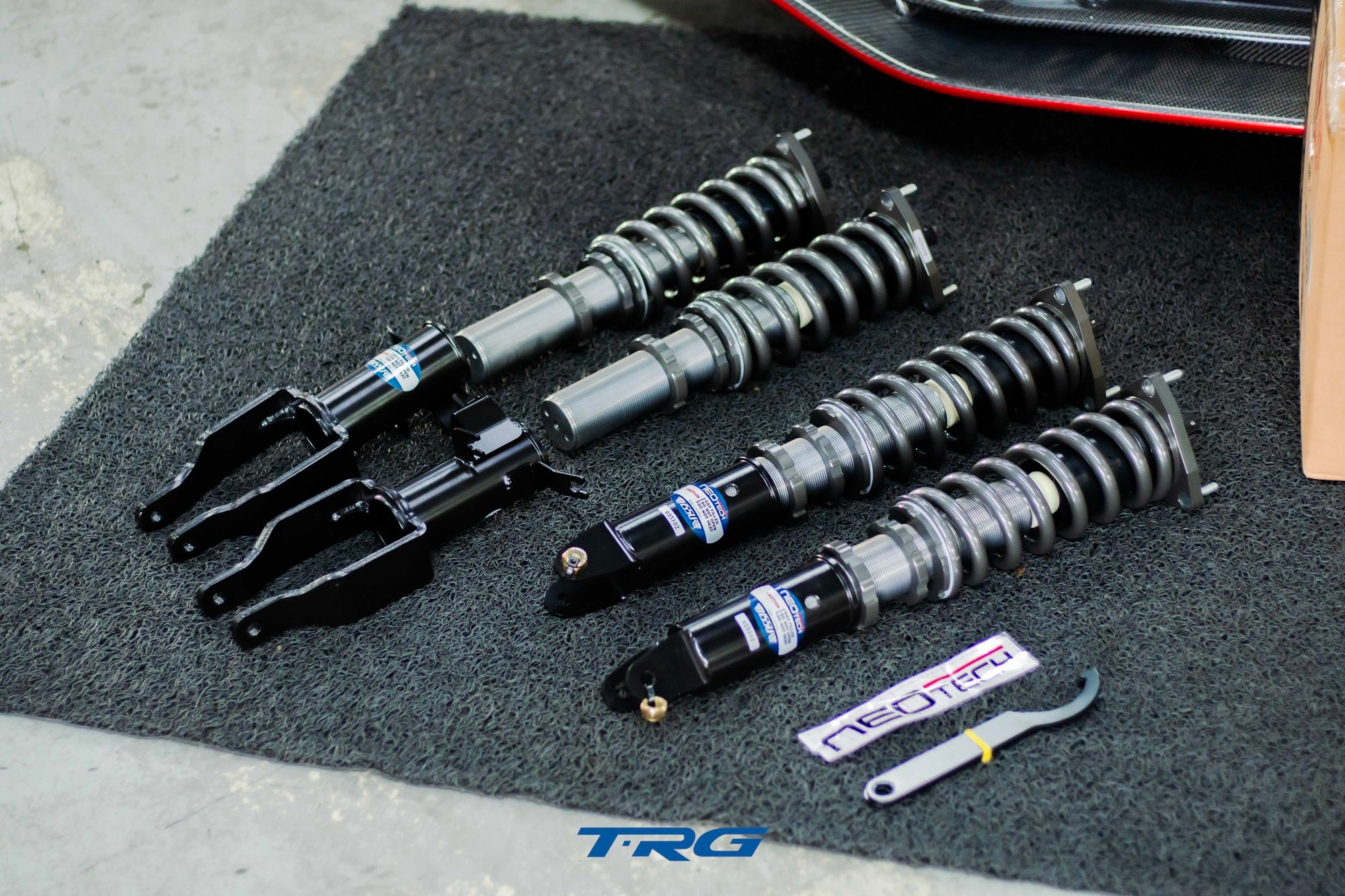 The full Neotech coilover kit laid out, two front units with fork brackets and two rear units with eye mounts