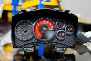 Bare Nismo combination meter assembly on a bench, carbon look fascia, 340 km/h speedo and red nismo tachometer